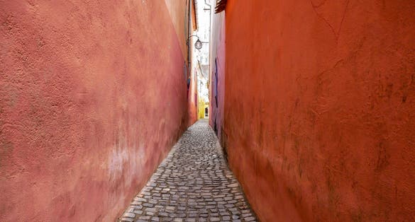 Photo of The colorful Rope Street ( in Romanian Strada Sforii) on medieval streets in Transylvania, Brasov city, one of the narrowest streets in Europe.