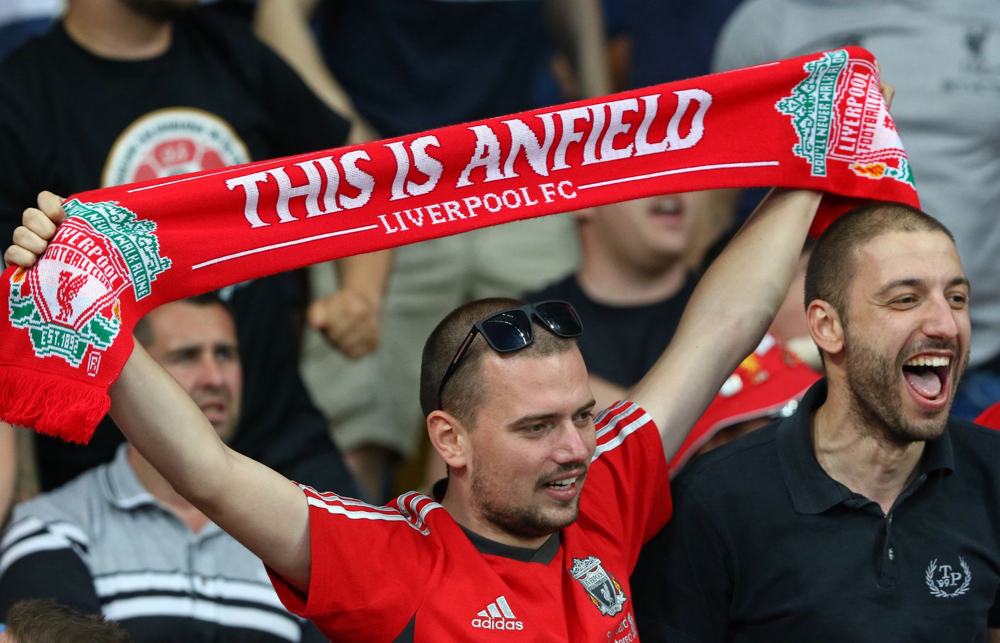  Liverpool supporter with This Is Anfield scarf shows his support.