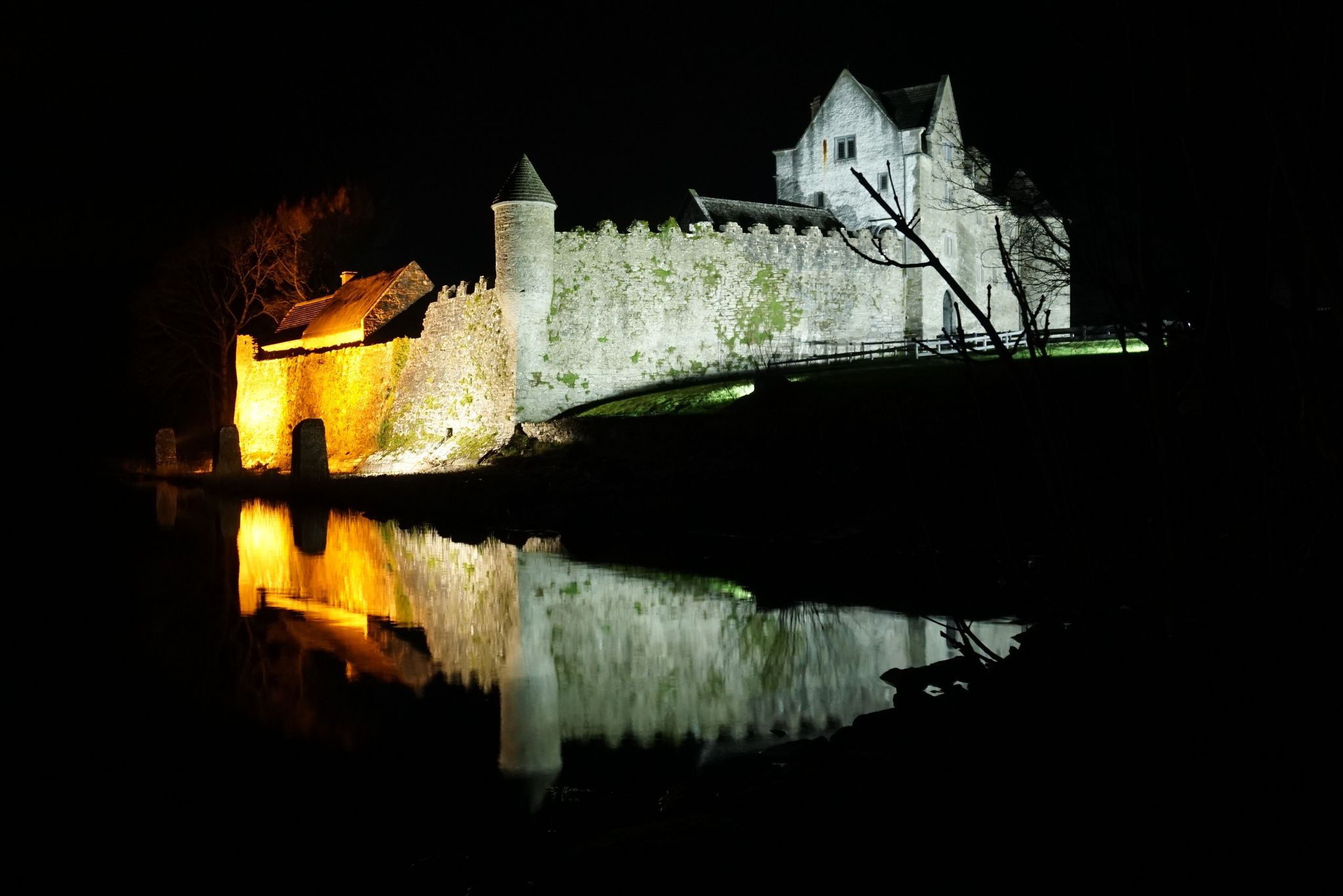 photo of Parke's Castle, County Leitrim, Ireland at night time reflected on waters of Lough Gill .