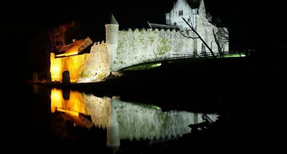 photo of Parke's Castle, County Leitrim, Ireland at night time reflected on waters of Lough Gill .
