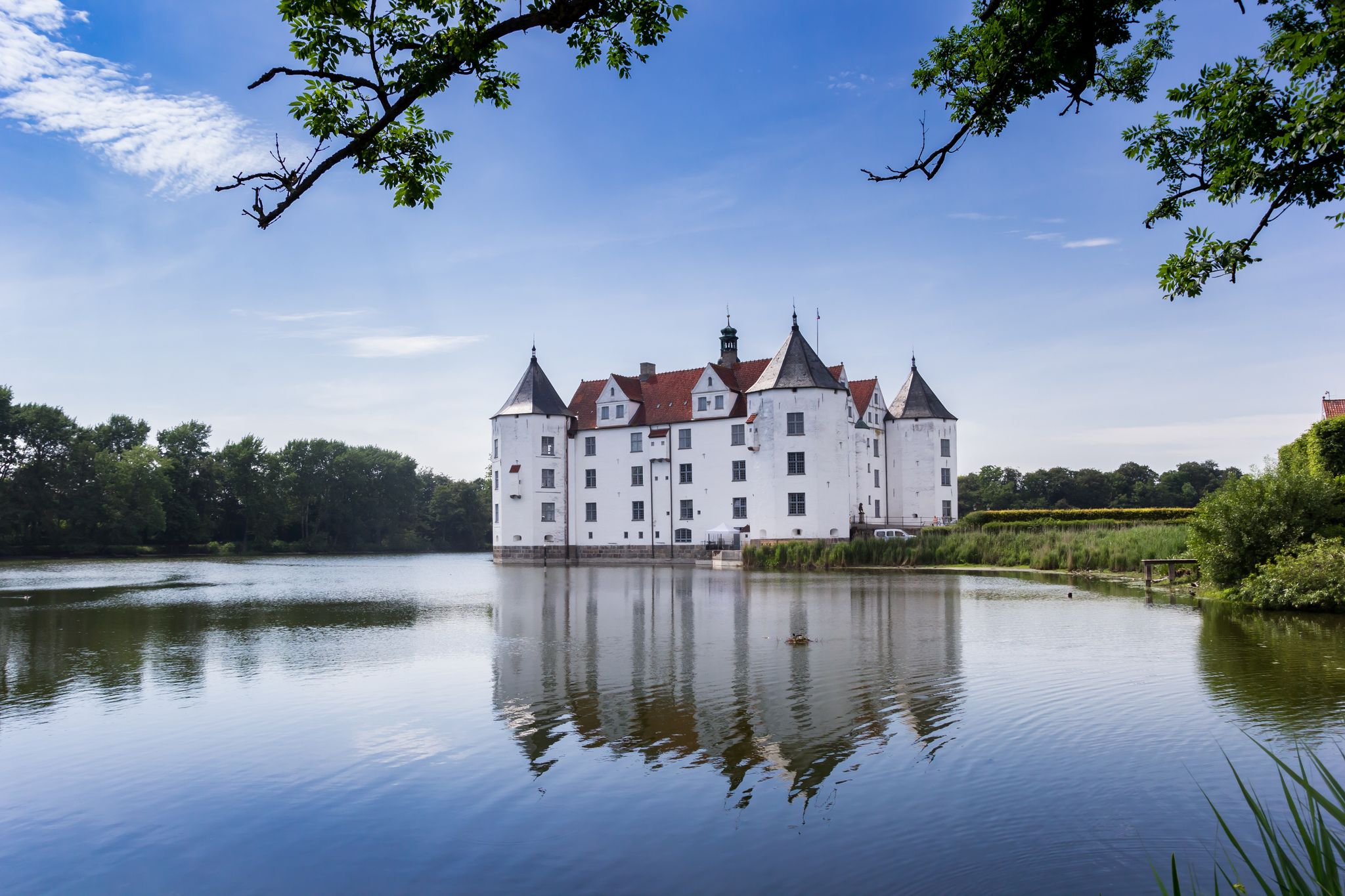 photo of view of Historic castle with reflection in the lake in Glucksburg, Germany.