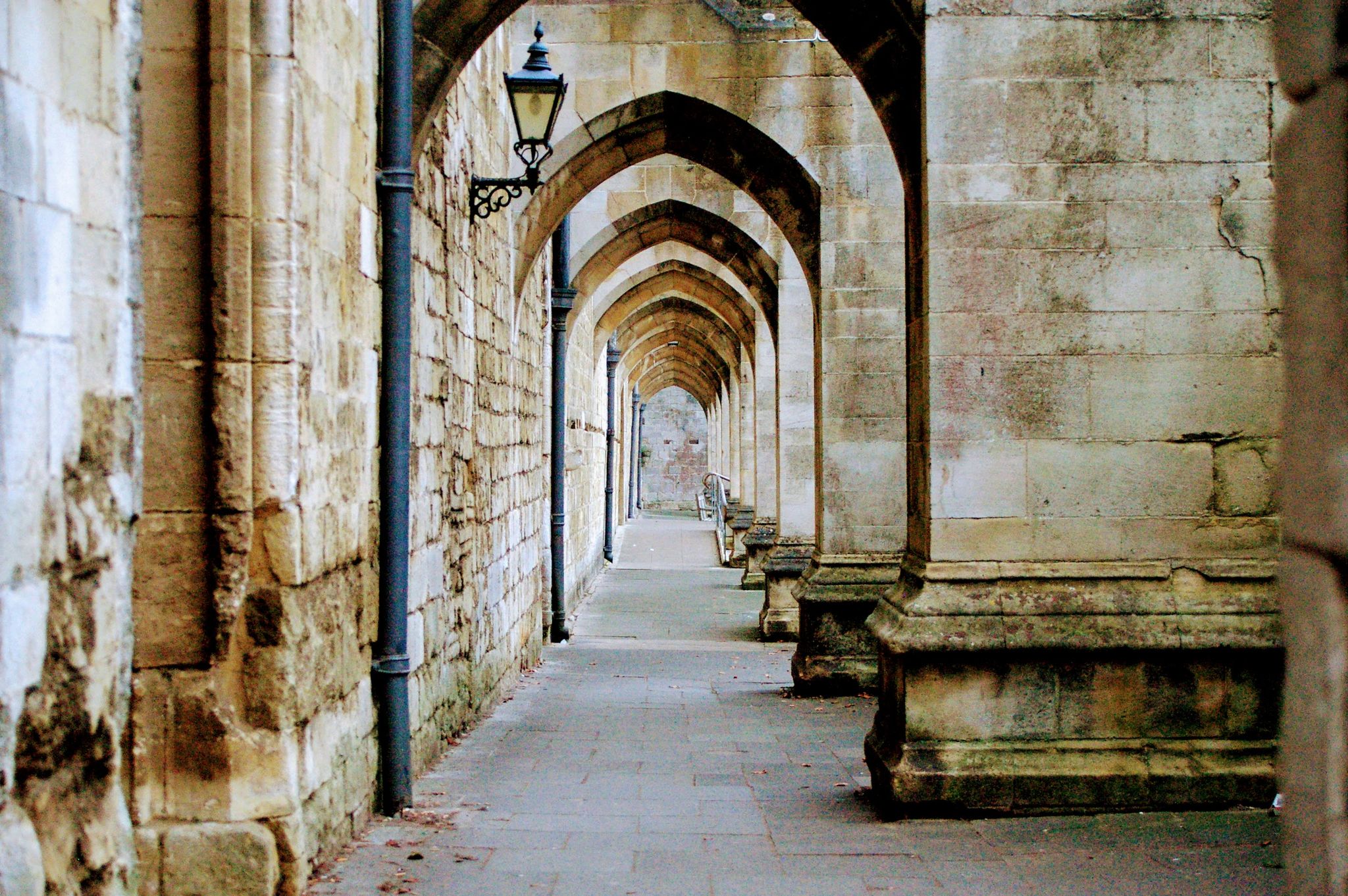 Photo of great medieval engineering, looking through the arches underneath the flying buttresses of the Winchester Cathedral, UK.