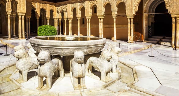 Photo of Patio de los Leones inside of the Nasrid palace of Alhambra fortress in Granada, Spain.