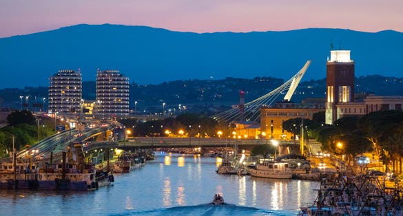 The view in the dusk from Ponte del Mare monumental bridge in the canal and port of Pescara city, Abruzzo region.