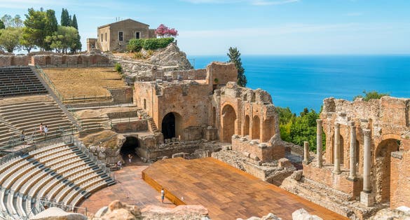 Ruins of the Ancient Greek Theater in Taormina on a sunny summer day with the mediterranean sea. Province of Messina, Sicily, southern Italy.