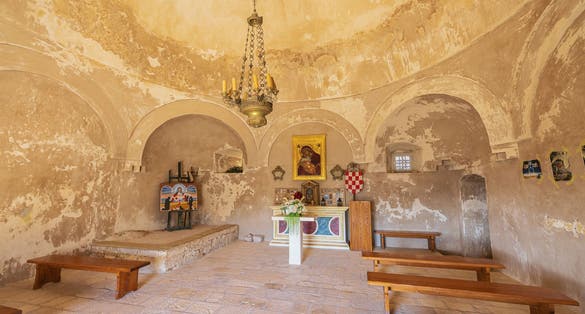 Photo of The altar and some artwork in St. Vitus church inside the Klis fortress, a converted mosque, Croatia.