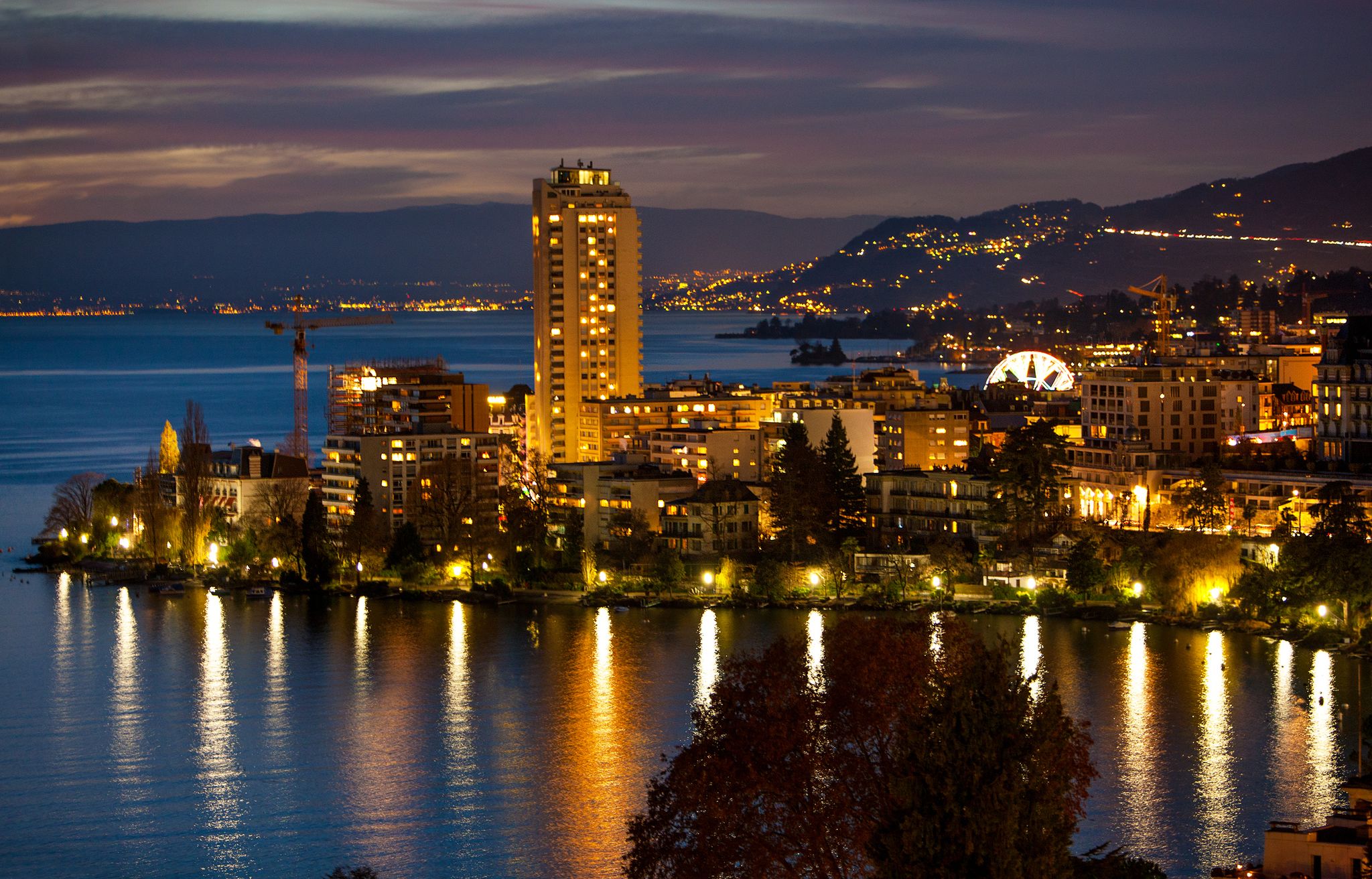 Night cityscape of Montreux Switzerland with land and ferris wheel.