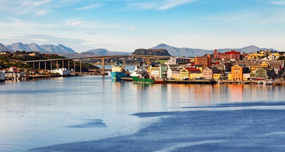 photo of view of Kristiansund cityscape with colorful waterfront buildings and moored ships, More og Romsdal, Norway.