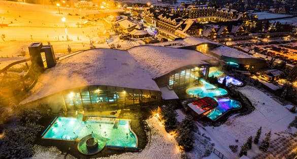 photo of drone view of Bania Thermal Baths at winter night in Zakopane, Poland.