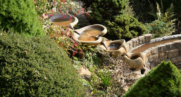 Photo of beautiful waterfall and Vesica Pool in the Chalice Well Garden, Glastonbury, England.