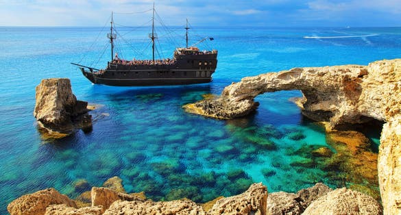 Photo of pirate ship sailing near famous Bridge of Love ,Cape Greco ,Ayia Napa, Cyprus. 