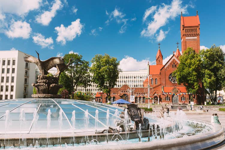 Photo of church of Saints Simon And Helen or Red Church And Fountain At Independence Square In Minsk.