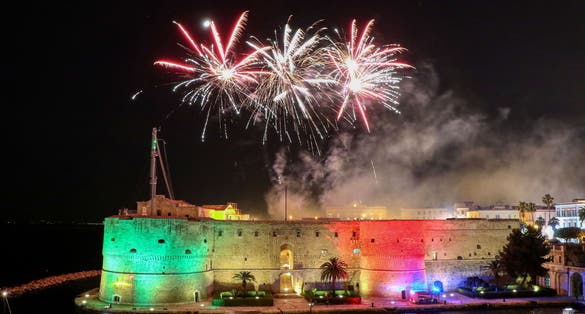 photo of Aragonese Castle (officially called the Castel Sant'Angelo) at night with fireworks on the feast of San Cataldo, Patron Saint of Taranto, Puglia, Italy.