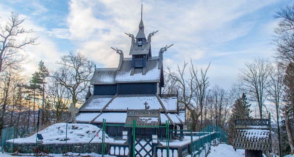 Old wooden Fantoft Stave Bergen Norway church in winter snow adn sunrise.