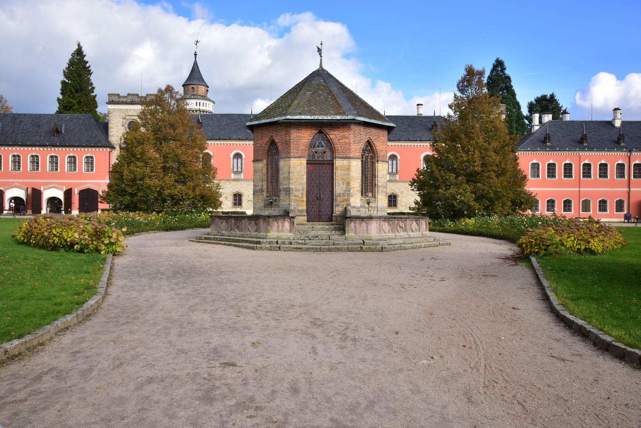 Photo of Sychrov Castle with typical pink facade. Neo-Gothic style chateau with beautiful english style park. Bohemian Paradise, Czech Republic.