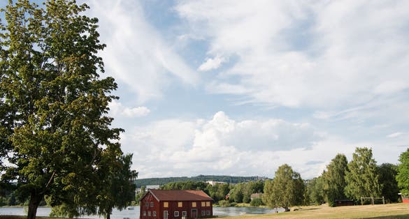 photo of view of red house near lake under cloudy sky, Hamar, Hedmark, Norway.