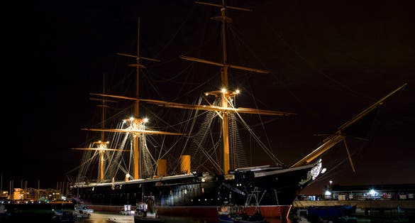 Photo of HMS Victory the Admiral Horatio Nelson's flagship at night at the Battle of Trafalgar in 1805 at Portsmouth Historic Dockyard, UK.