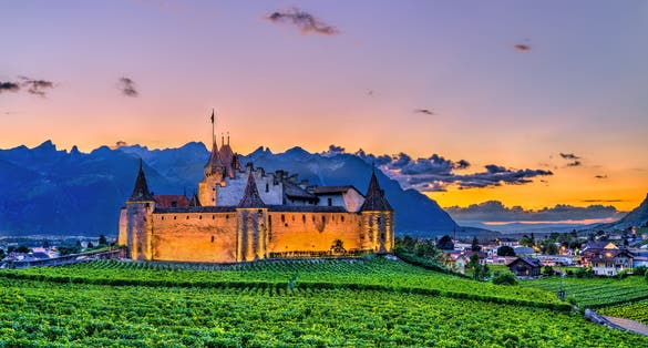 photo of view of Aigle Castle with vineyards in the Canton of Vaud at sunset. Switzerland.