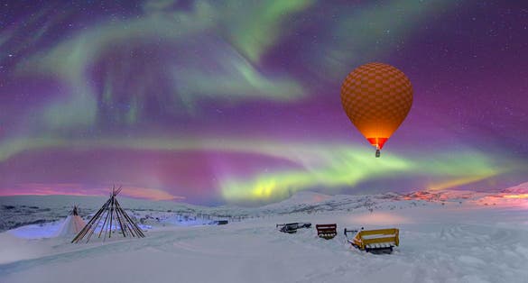 Photo of Northern lights in the sky and triangle cloth tent with hot air balloon - Tromso, Norway