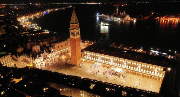 Aerial drone night shot of iconic illuminated Saint Mark's square or Piazza San Marco featuring Doge's Palace, Basilica and Campanile, Venice, Italy.
