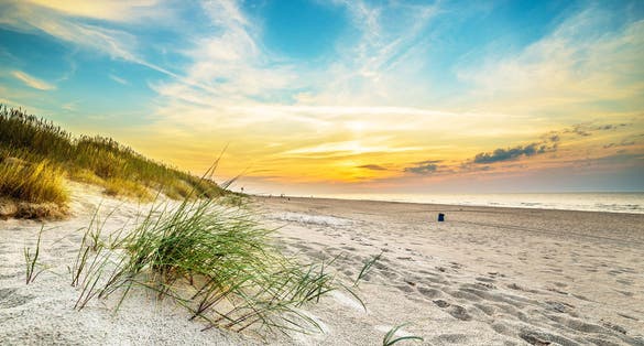 Photo of sand dunes against the sunset light on the beach in northern Poland.