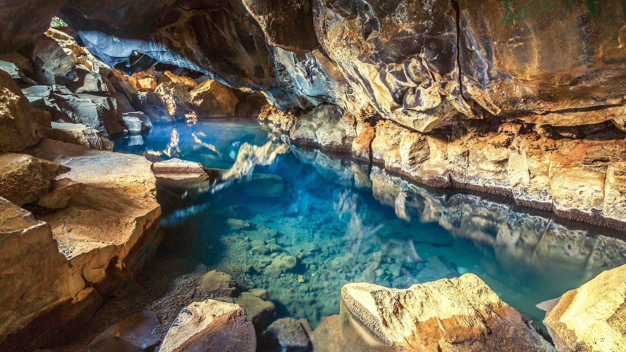 photo of view of Grjótagjá volcanic hot springs cave, near Reykjahlid, Mývatn, Iceland, with blue and transparent water., Reykjahlíð, Iceland.