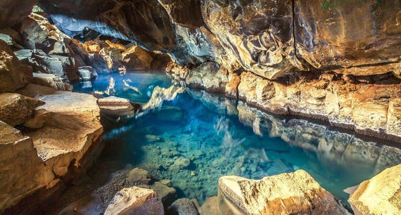 photo of view of Grjótagjá volcanic hot springs cave, near Reykjahlid, Mývatn, Iceland, with blue and transparent water., Reykjahlíð, Iceland.