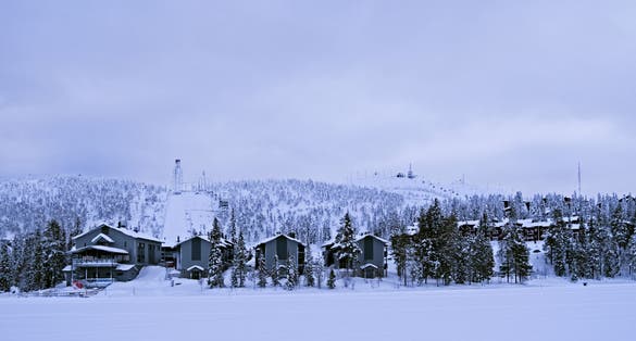 Photo of the Ruka ski area with the big ski jump and several lifts around the Rukatunturi fell on a snowy day.
