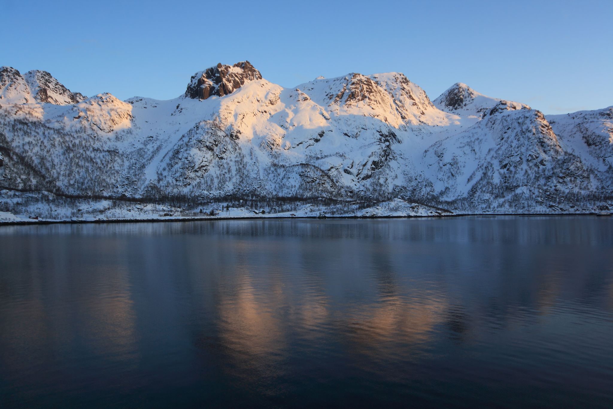 photo of view of Winter in Raftsund between the Norwegian archipelagos of Lofoten and Vesteralen. View from a cruise ship between Stokmarknes and Svolvaer in the Raftsund at sunset.