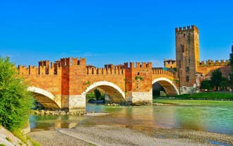 Photo of aerial view of Verona historical city centre, Ponte Pietra bridge across Adige river, Verona Cathedral, Duomo di Verona, red tiled roofs, Veneto Region, Italy.