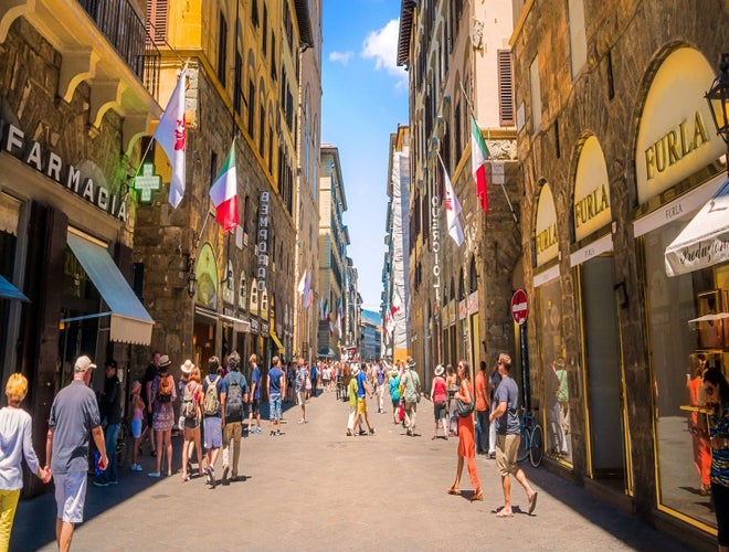 Tourists walking through historic shopping streets in Florence under the summer sun in June..jpg