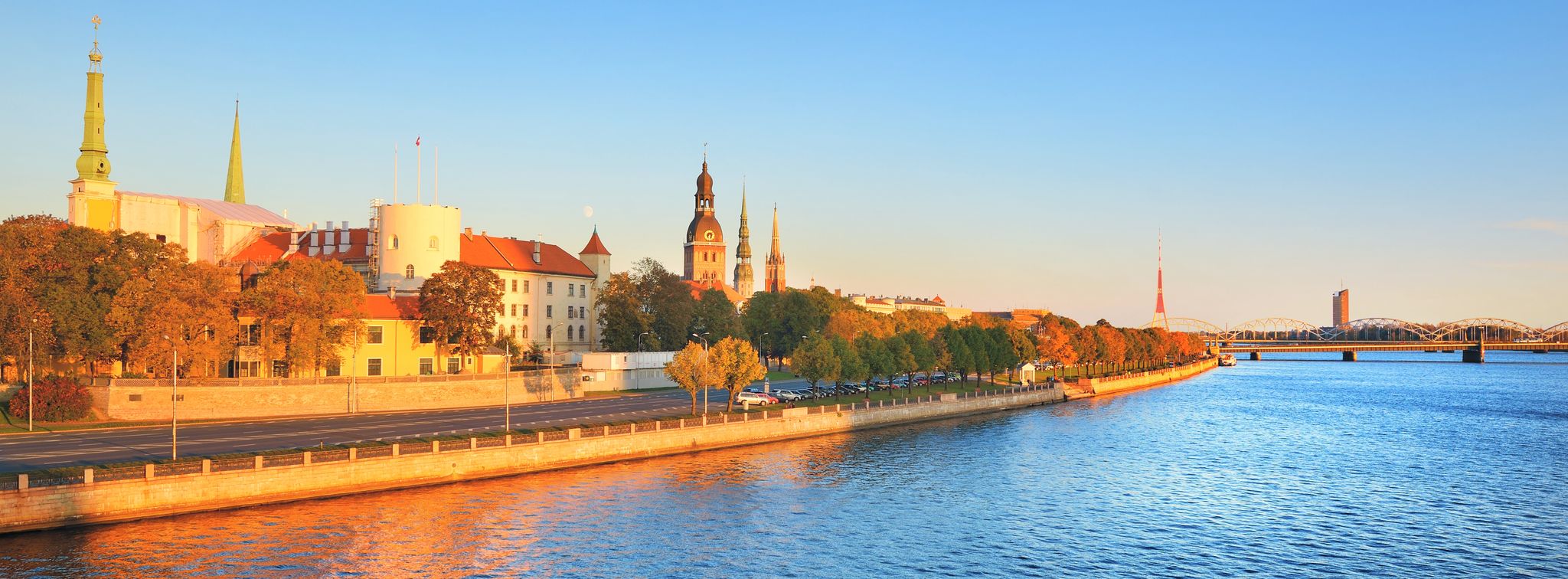 Aerial view of Riga embankment on a sunny day. Panoramic autumn cityscape. Fortress, cathedral and railway bridge close-up. Vacations in Latvia, travel destinations, national landmarks, sightseeing