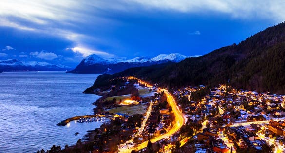 photo of view of  Molde, Norway. Aerial view of residential area in Molde, Norway at night. Beautiful fjord with mountains in winter