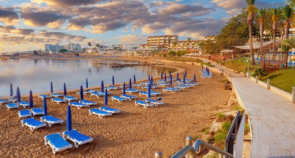 Photo of Kalamies beach in Protaras city. Beach with blue sunbeds and umbrellas.