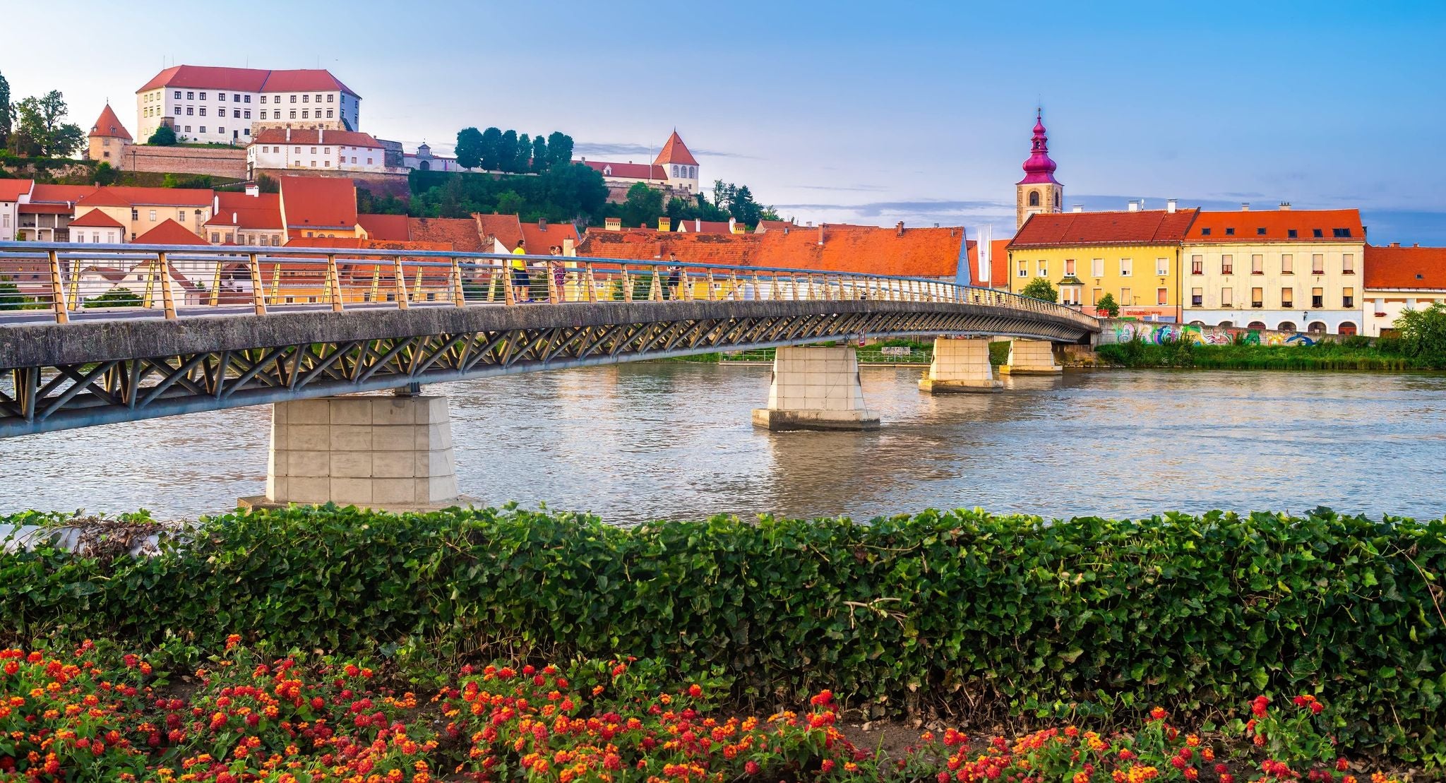 Pedestrian bridge over the Drava River with historic architecture in the town of Ptuj, Slovenia..jpg