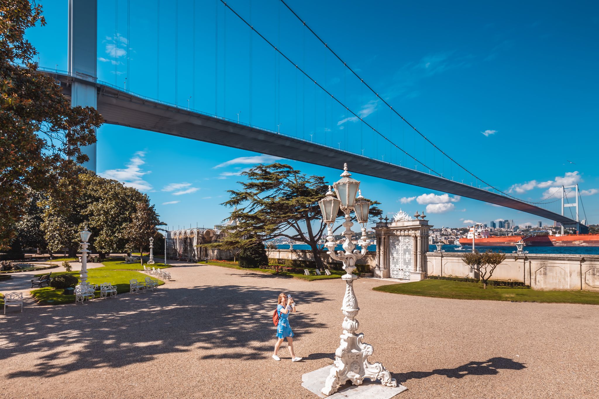 photo of a young girl in Beylerbeyi Palace garden with ornated gate located in the Beylerbeyi neighborhood of Uskudar district in Istanbul, Turkey. An Imperial Ottoman summer residence built in the 1860s.