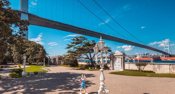 photo of a young girl in Beylerbeyi Palace garden with ornated gate located in the Beylerbeyi neighborhood of Uskudar district in Istanbul, Turkey. An Imperial Ottoman summer residence built in the 1860s.