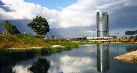 Photo of Parque del Agua Zaragoza, Water Tower and a lake with a nice reflection of the tower and a tree .