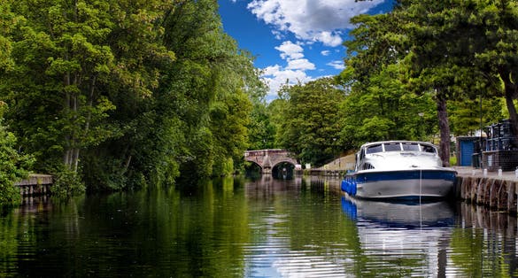 Photo of the tree lined banks of the river wensum in the city of Norwich.