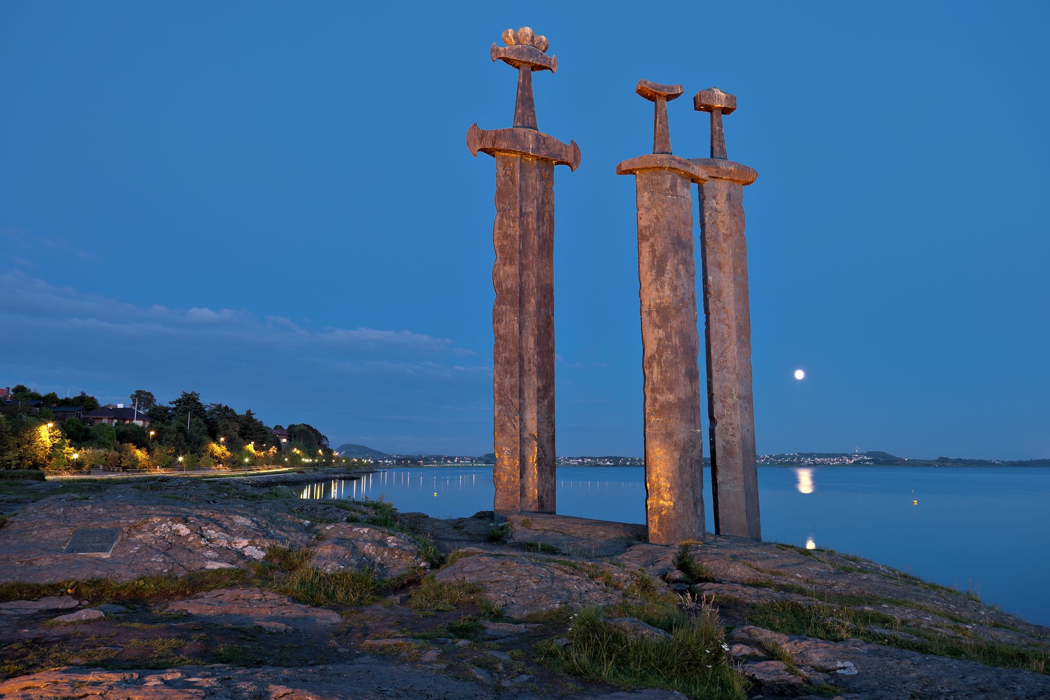 Photo of three large swords Sverd i Fjell at night stand on the hill as a memory to the Battle of Hafrsfjord in year 872 in Stavanger, Norway.
