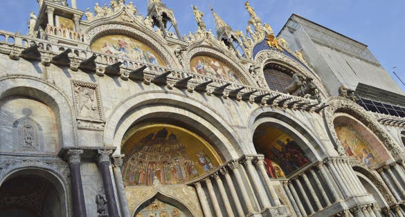 photo of Tourist site of St Mark's Square in Venice, Italy, tall St Mark's tower, the San Marco Basilica cathedral and other baroque and gothic sites in the most famous piazza in the city of Venezia.