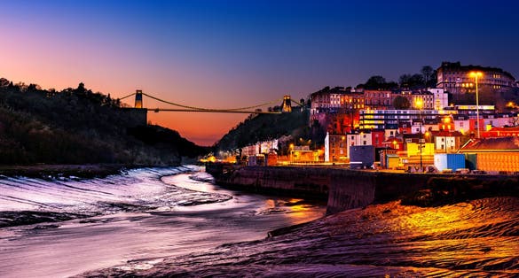 Panoramic photo of Clifton Suspension Bridge over the river Avon and Clifton Village, Bristol, England UK taken in the Blue Hour.