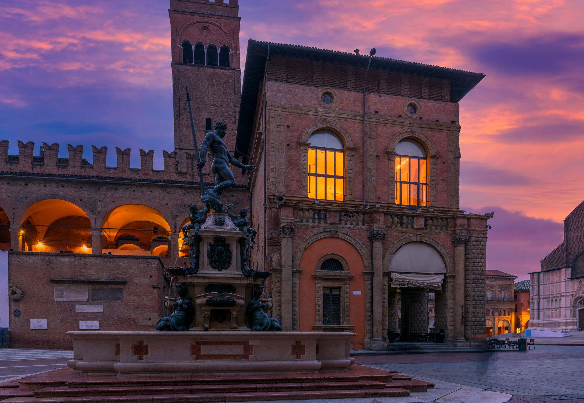 photo of Piazza del Nettuno and Fountain of Neptune in Bologna, Emilia-Romagna, Italy. Architecture and landmark of Bologna. Night cityscape of Bologna.