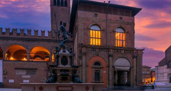 photo of Piazza del Nettuno and Fountain of Neptune in Bologna, Emilia-Romagna, Italy. Architecture and landmark of Bologna. Night cityscape of Bologna.