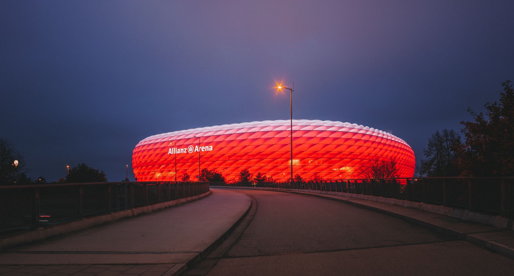 Photo of Allianz Arena, the football stadium of FC Bayern, illuminated in red at night, Germany.