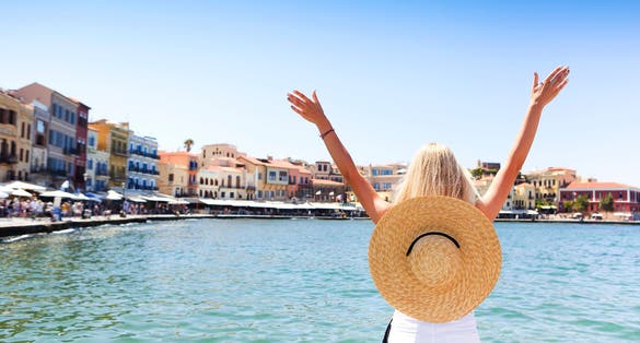 Photo of tourist woman in big hat enjoying the beautiful views of the port of Chania.
