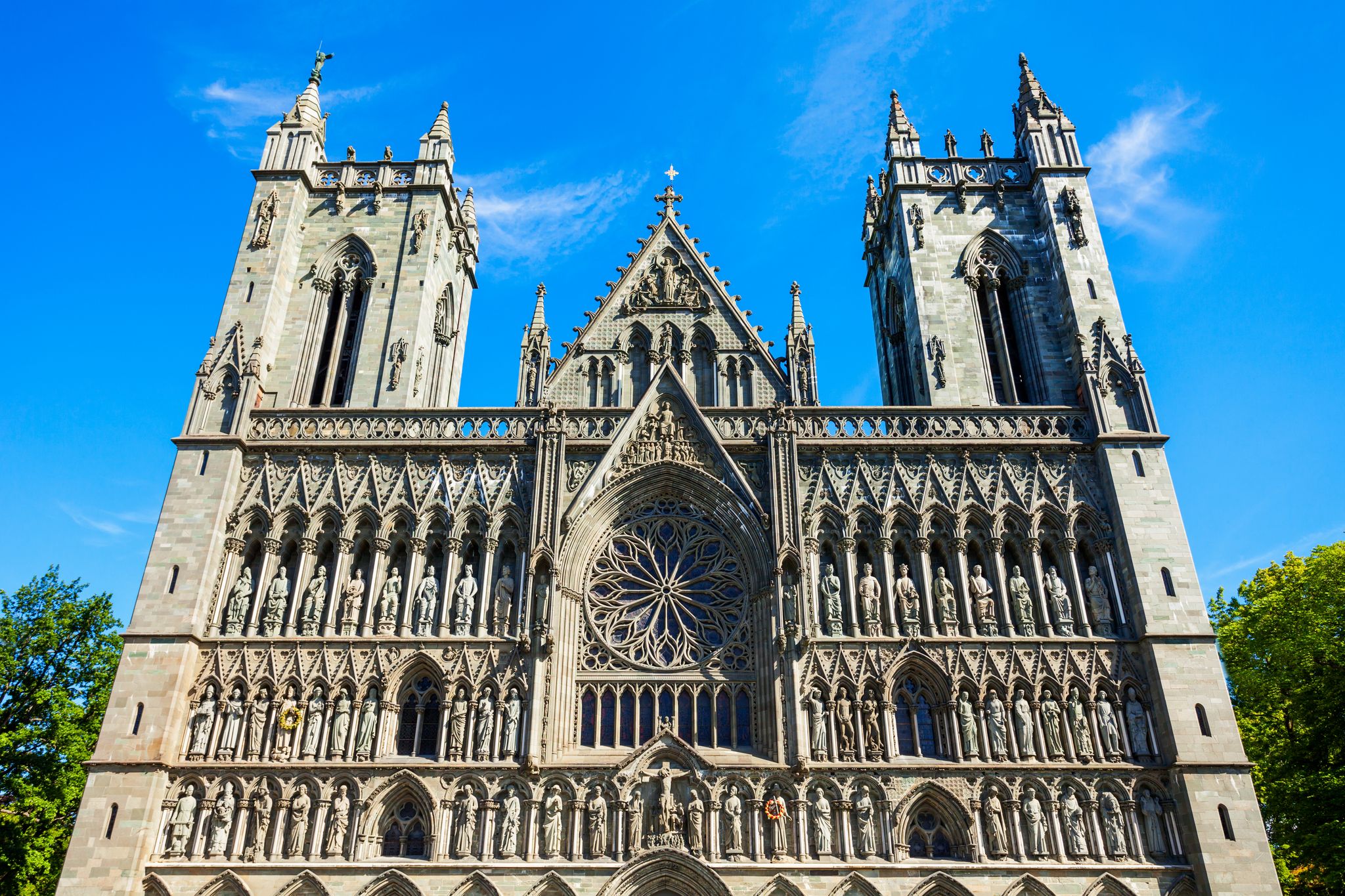 Photo of the western facade of Nidaros Cathedral in Trondheim, Norway, with a considerable quantity of sculptures with the image sacred, kings and bishops.