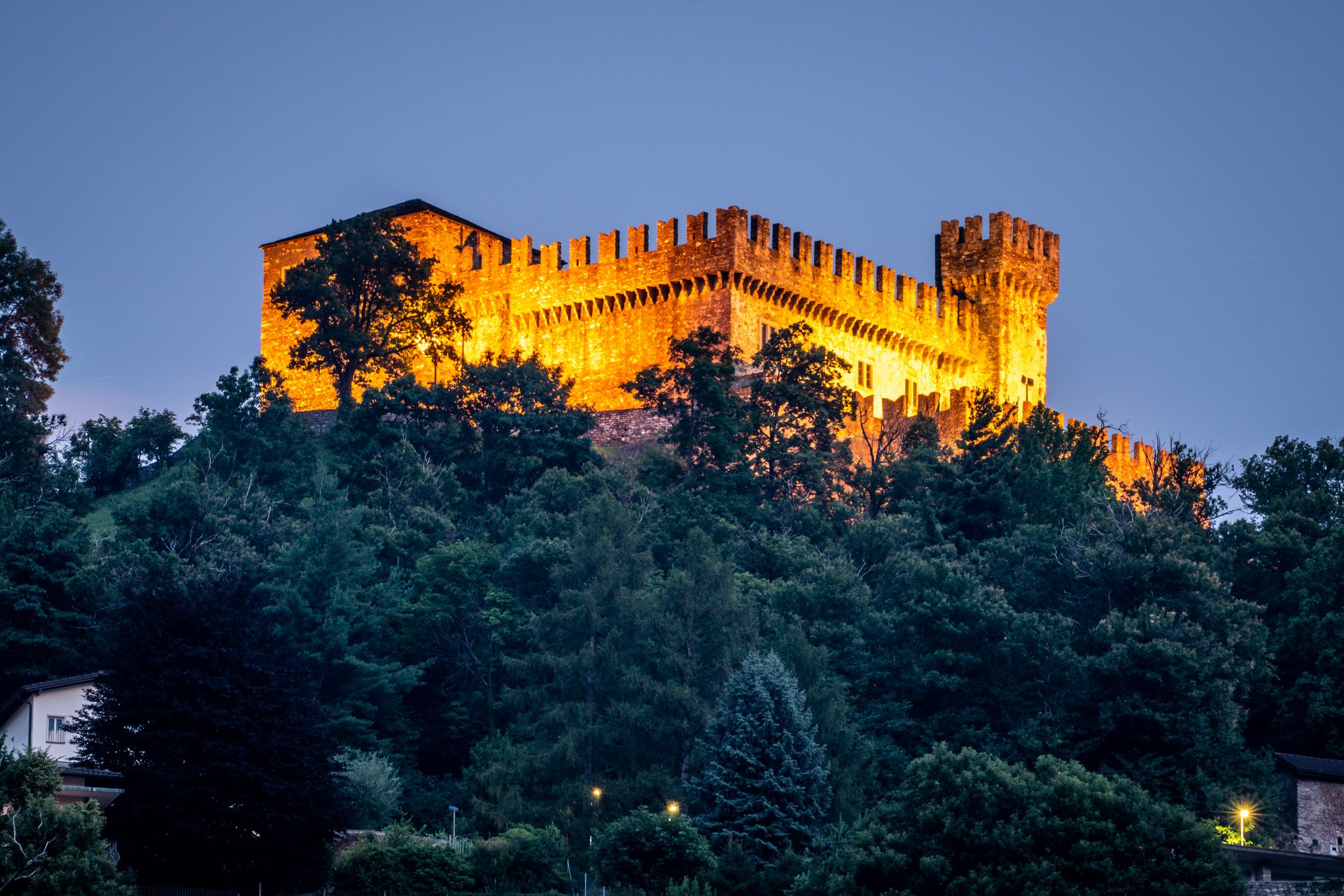 photo of Sasso Corbaro medieval castle illuminated at night in Bellinzona, Switzerland.