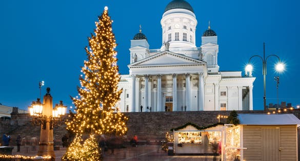 Photo of Christmas Xmas Holiday Carousel On Senate Square in front of Famous Landmark Lutheran Cathedral At Winter Evening, Helsinki, Finland.