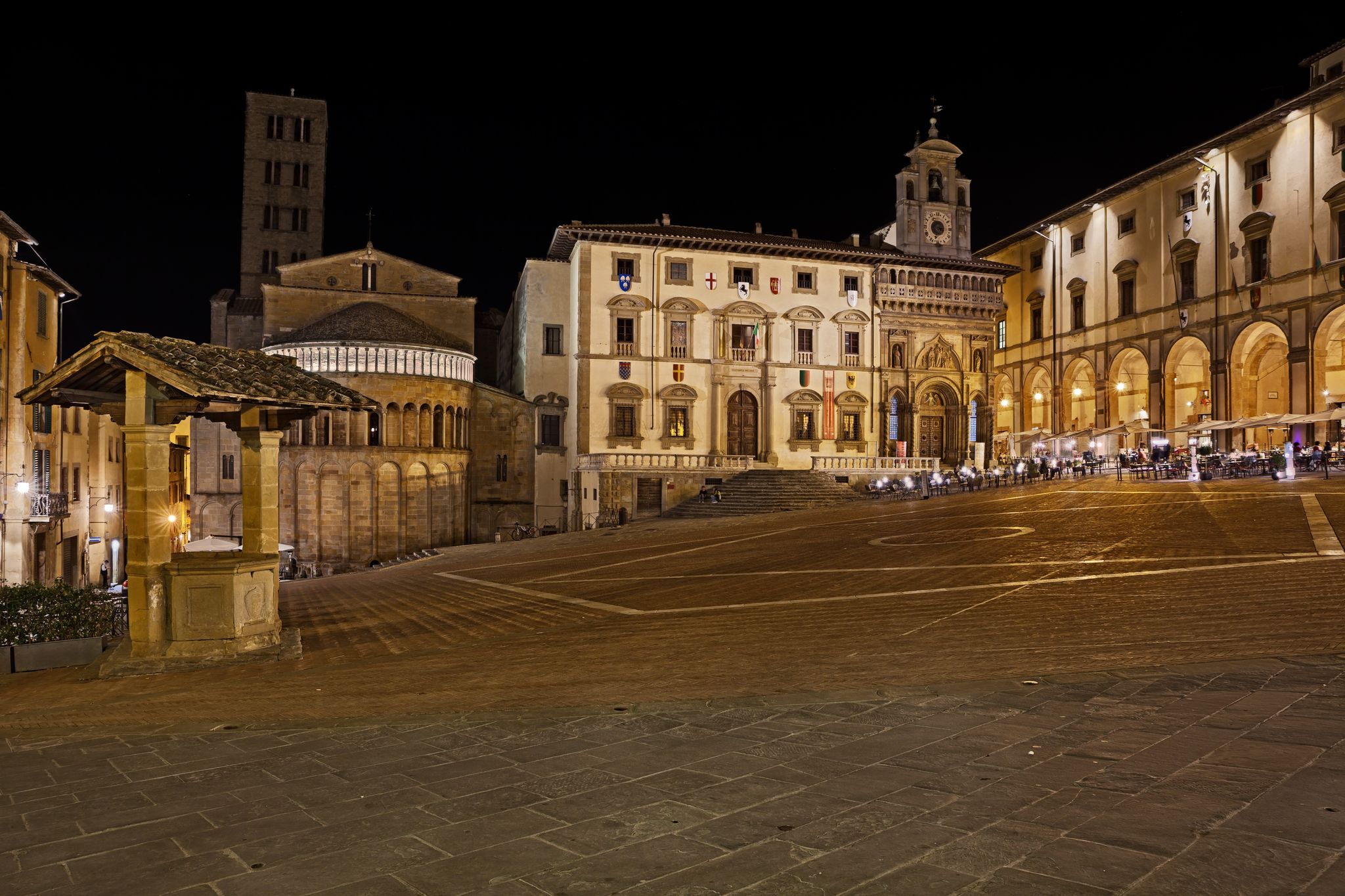 photo of view of Arezzo, Tuscany, Italy: night view of the main square Piazza Grande, with the medieval church and buildingsArezzo, Italy.